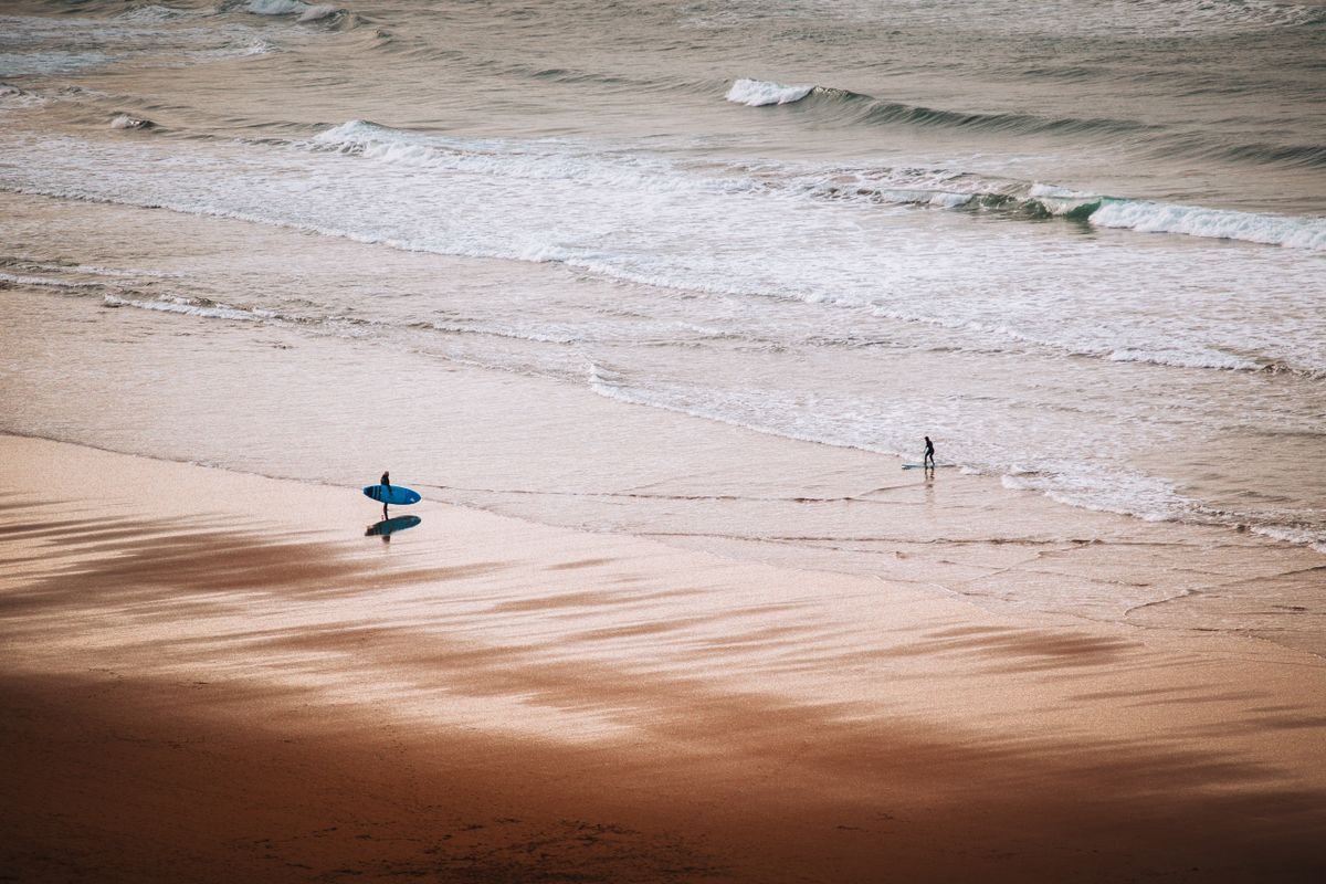 Surfer walking on the exposed Atlantic surf beach at Carrowniskey near Louisburgh