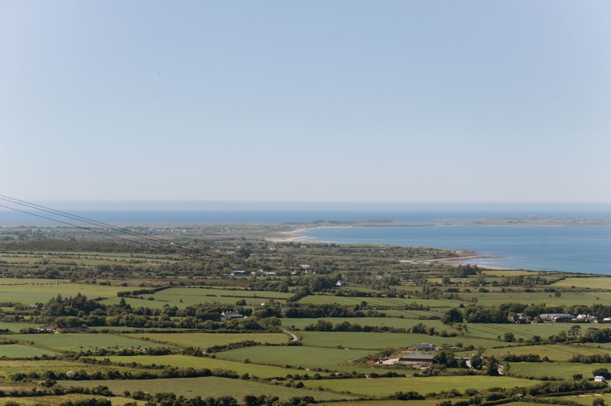 Green fields running down to the sea on the far coast past Louisburgh in Mayo
