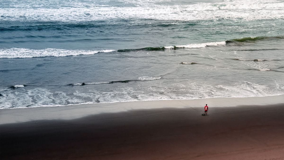 A long sandy beach with waves on the County Antrim coast