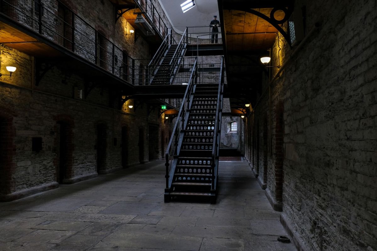 Interior atrium of Cork City Gaol with iron staircase and a wax figure of a warder