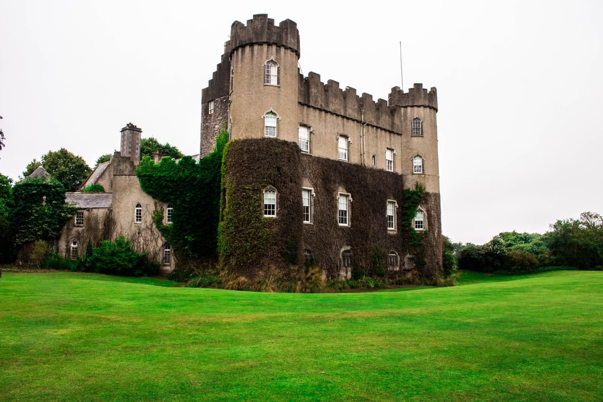 Malahide Castle with ivy-covered walls and a green lawn near Dublin