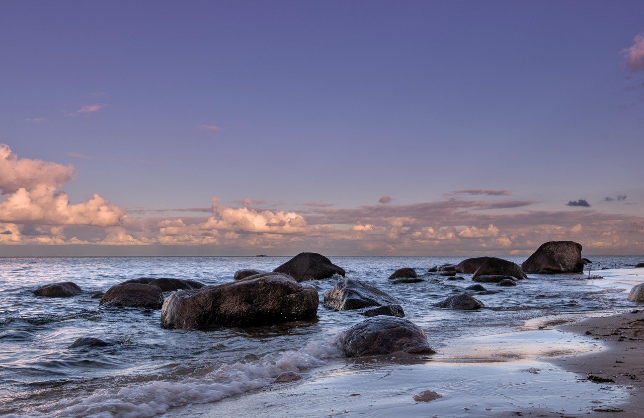 A calm evening sea with rocks along a quiet Irish beach in late summer
