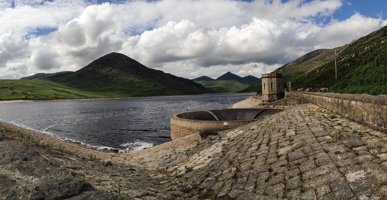 The dam and stone valve tower at Silent Valley Reservoir with the Mourne Mountains behind