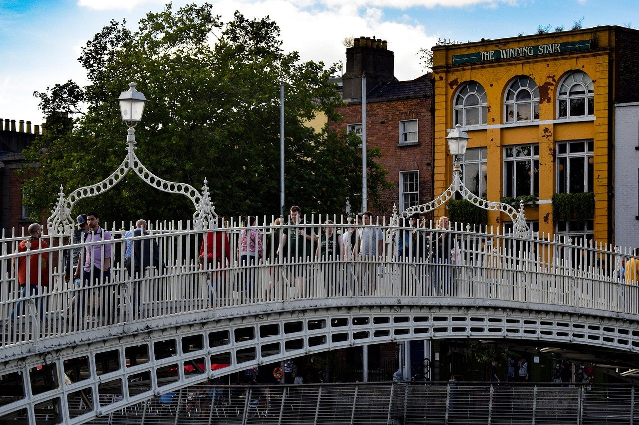 People crossing the Ha'penny Bridge over the River Liffey in Dublin