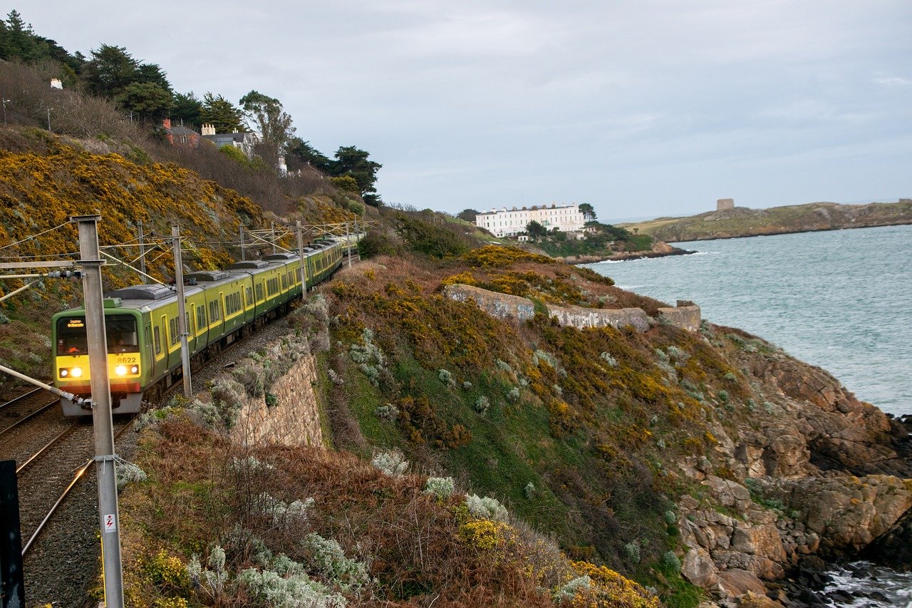 Green and yellow DART train running along the coast near Dublin