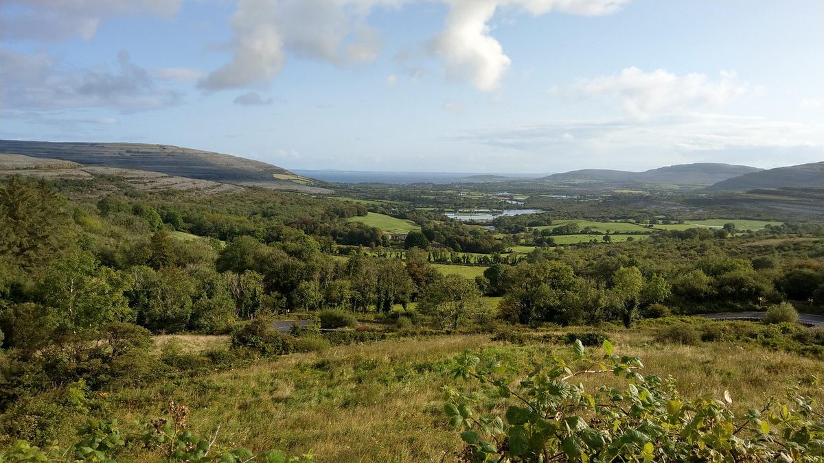 Green valley folding into the limestone hills of the Burren