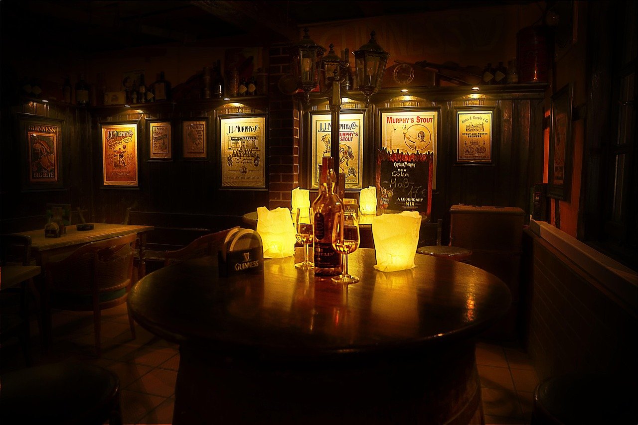 Warm wooden interior of a traditional Irish pub with a barrel table and vintage posters