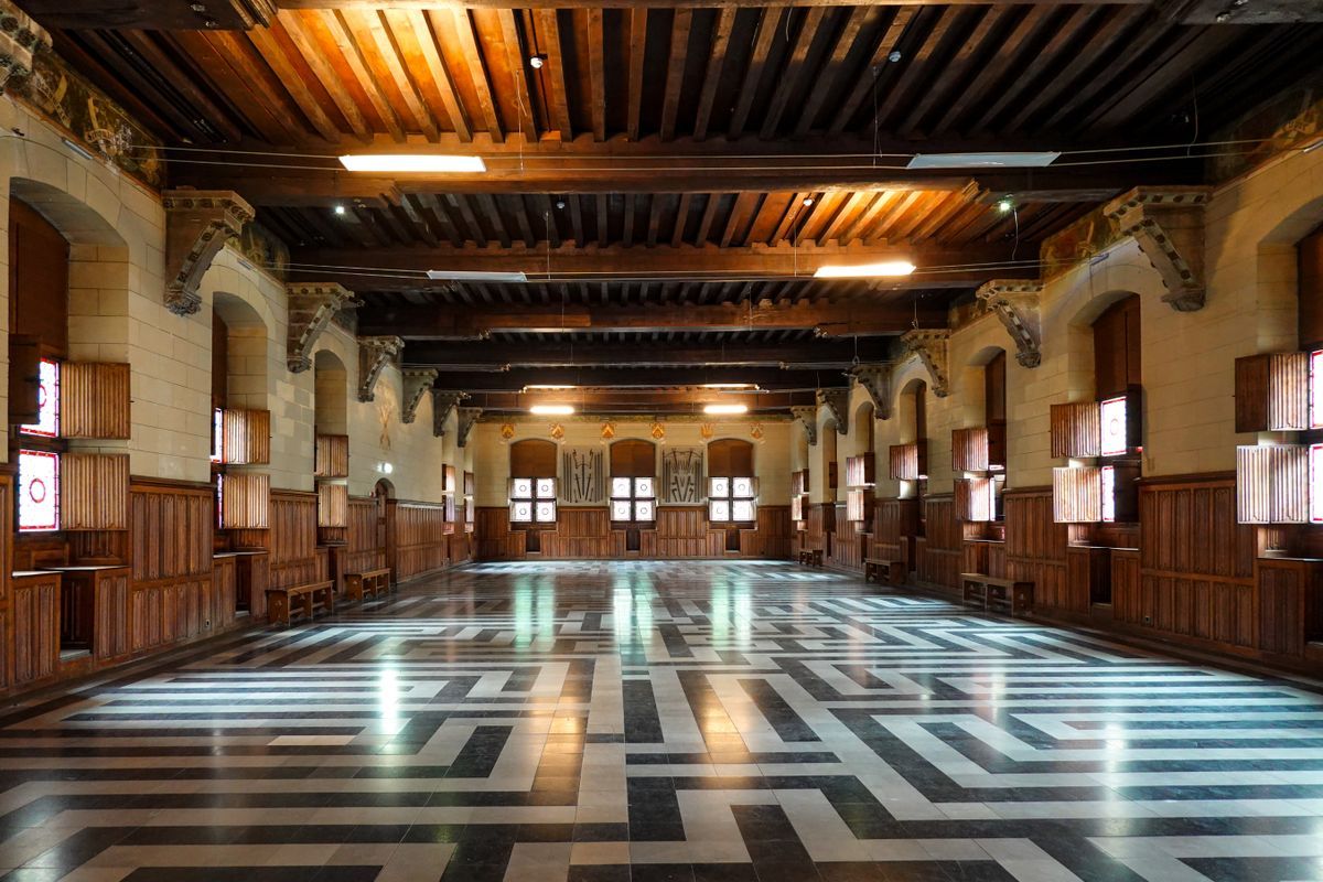 Great hall inside a medieval castle with beamed ceiling and stone walls