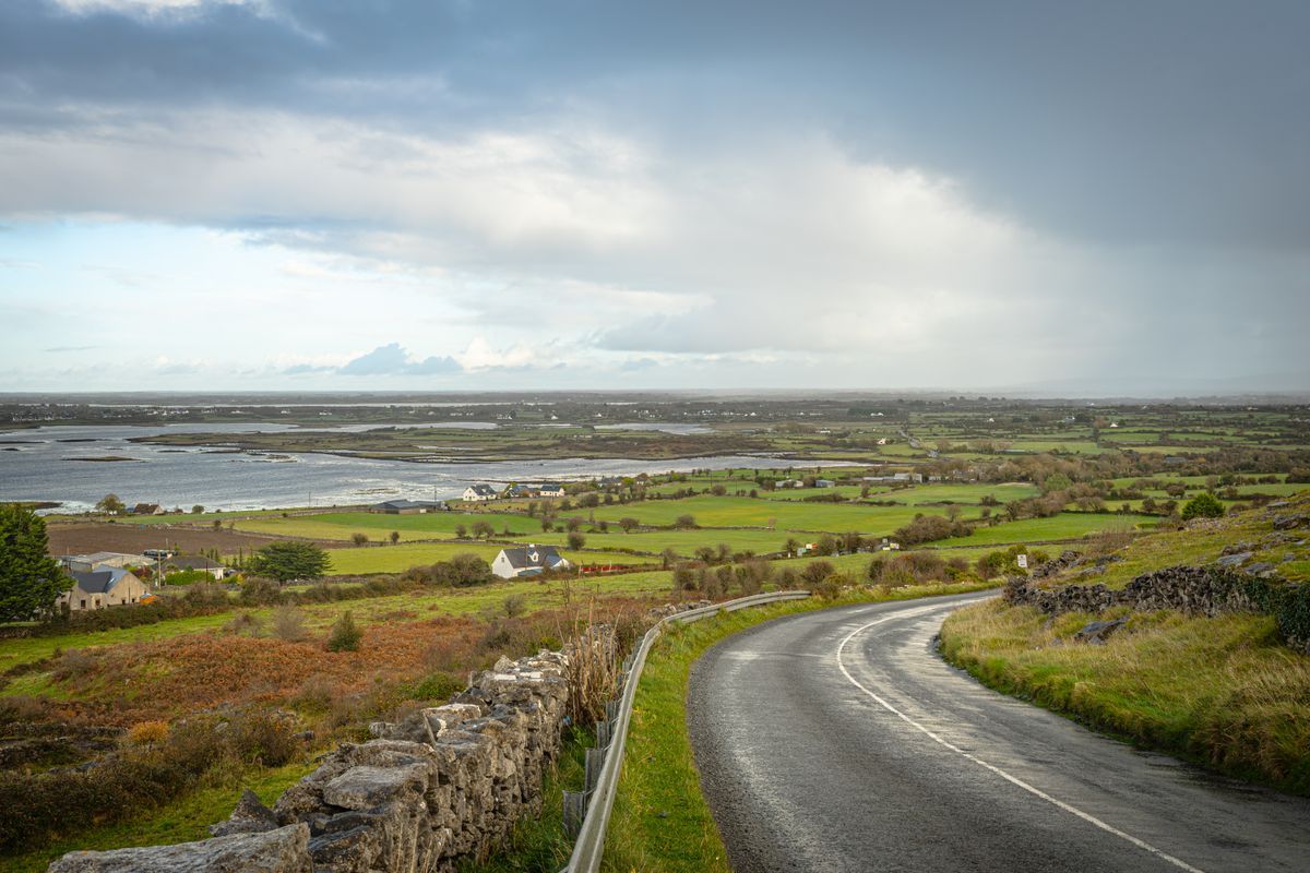 Winding rural road through County Clare with stone walls