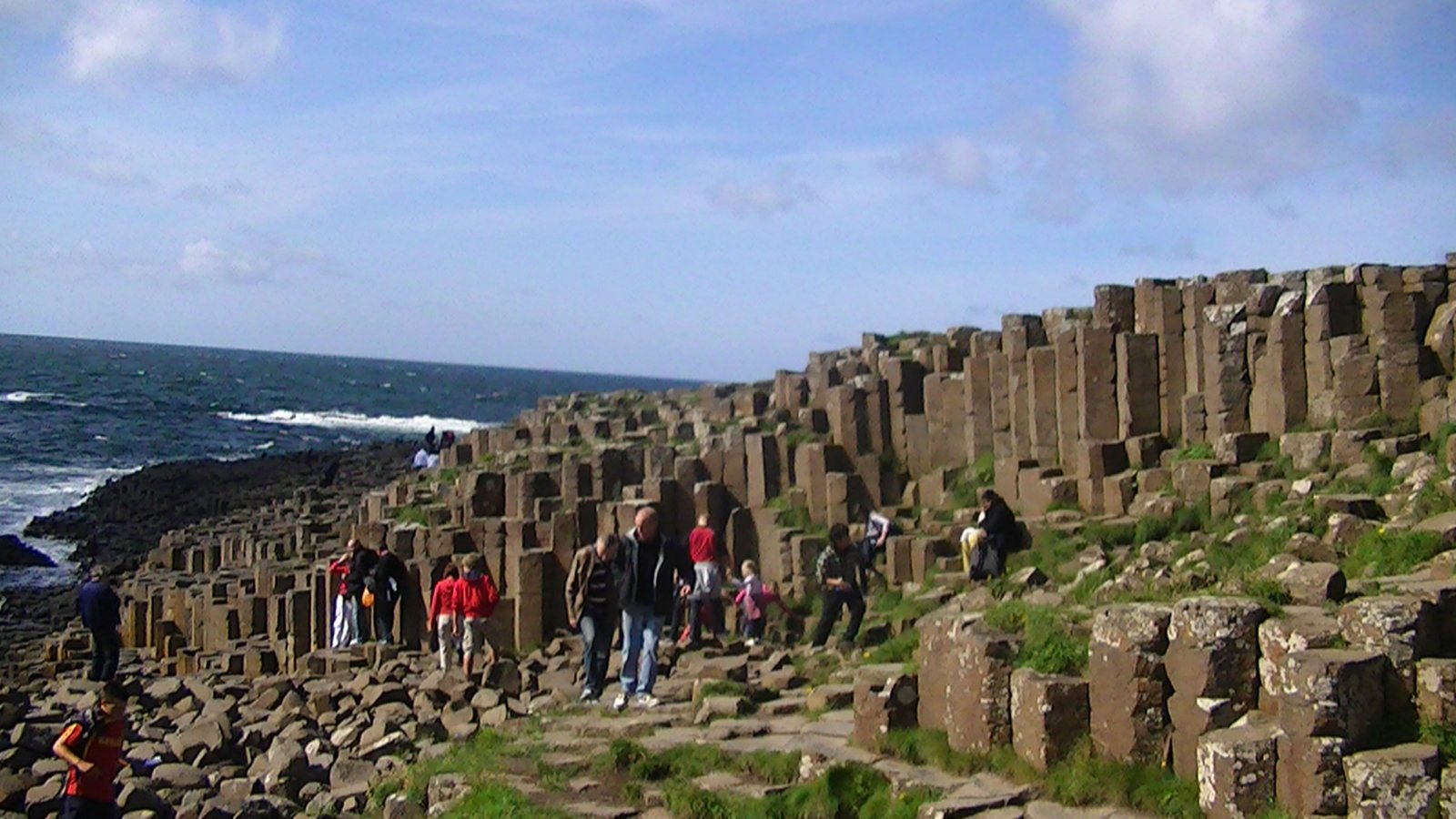 Visitors spread across the Giant's Causeway stones on a busy summer day