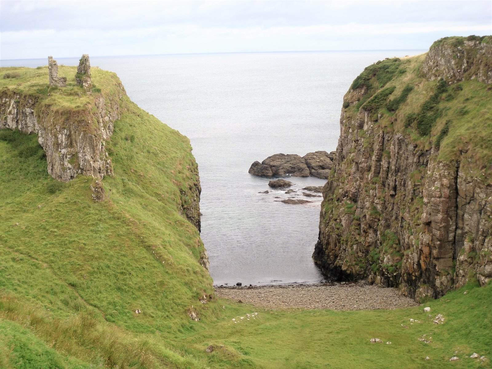 The ruins of Dunseverick Castle on a green headland on the Causeway Coast