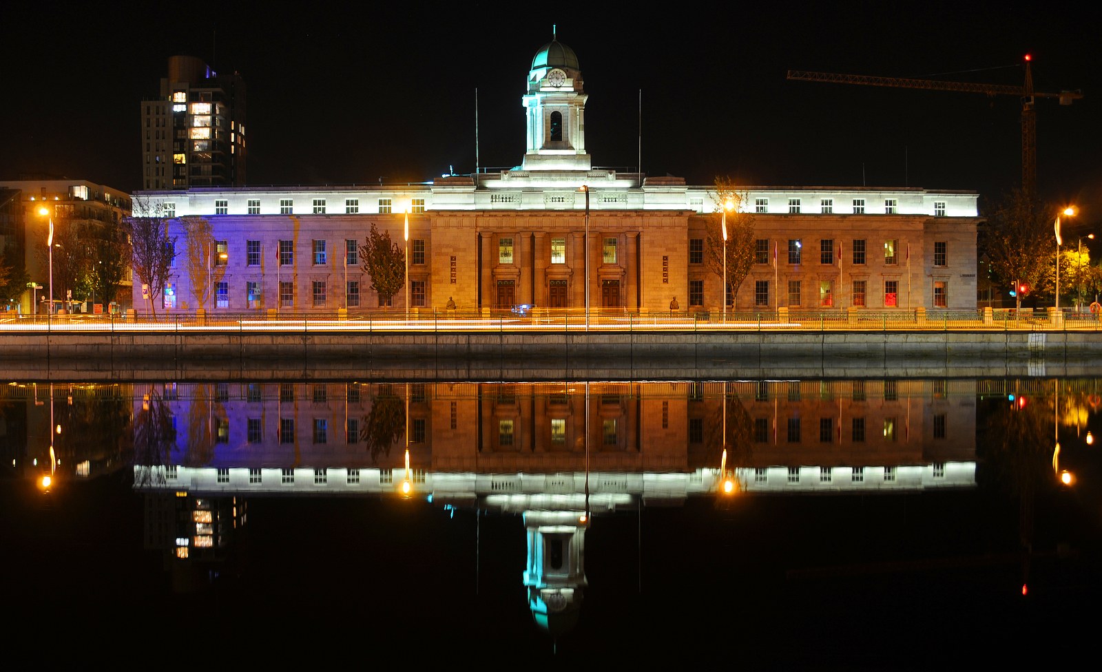 Cork City Hall illuminated beside the River Lee at night