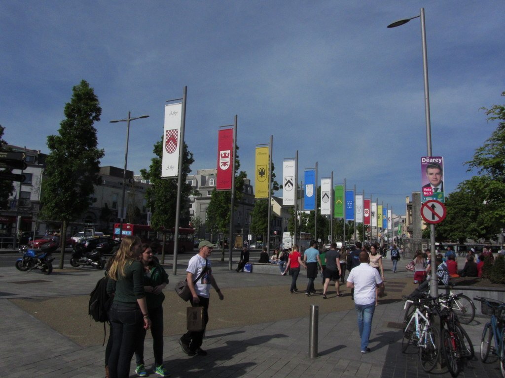 Flags above pedestrians at Eyre Square in Galway