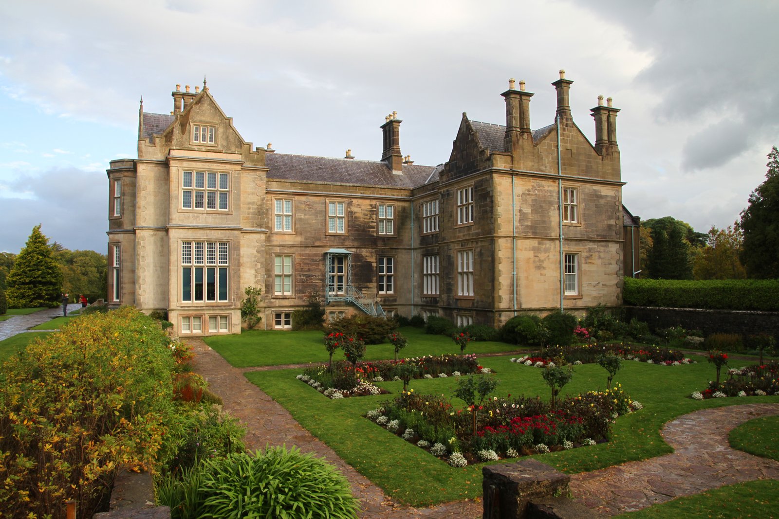 Muckross House and its gardens beneath an overcast sky