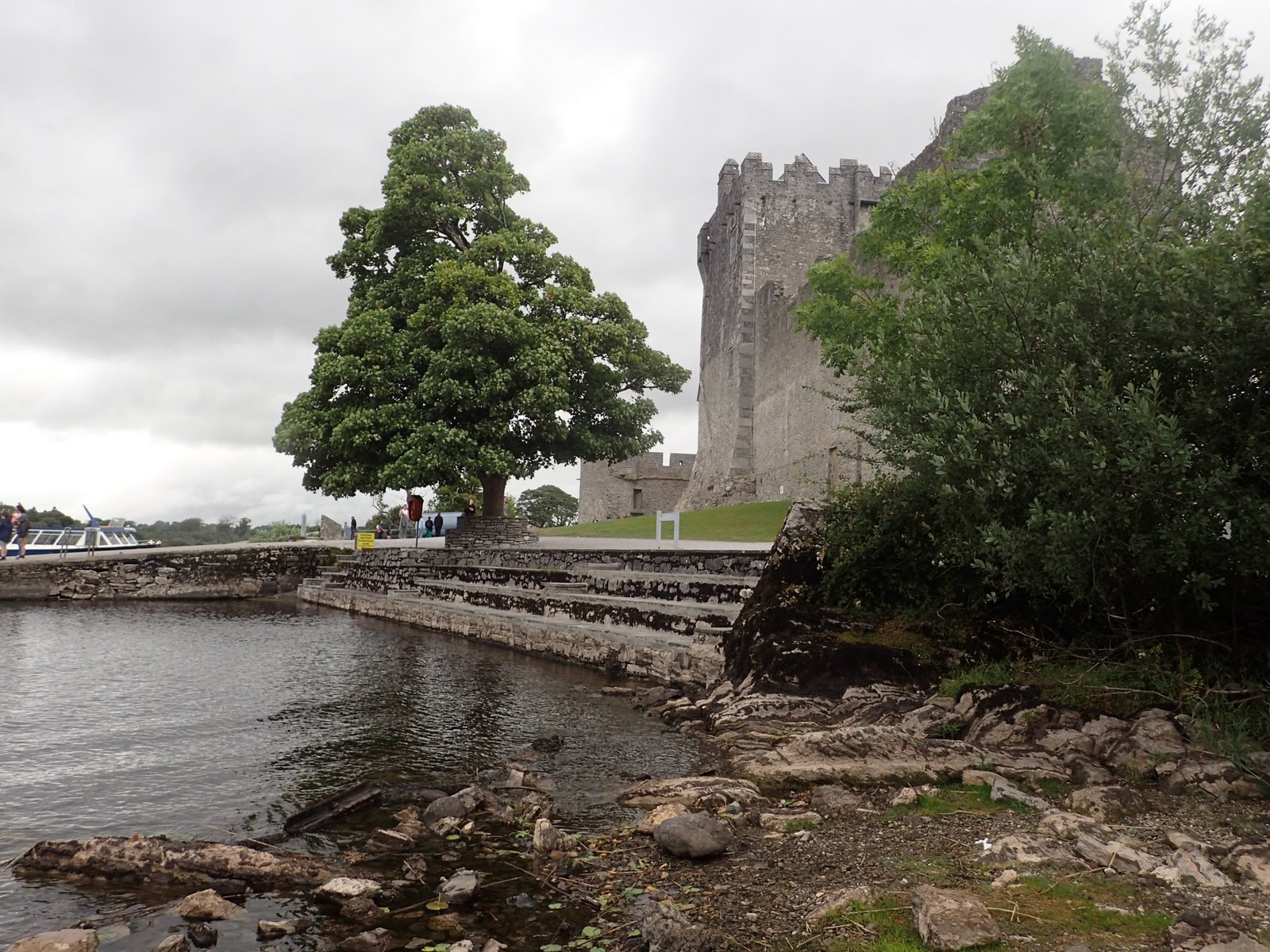 Ross Castle and boats along the shore of Lough Leane