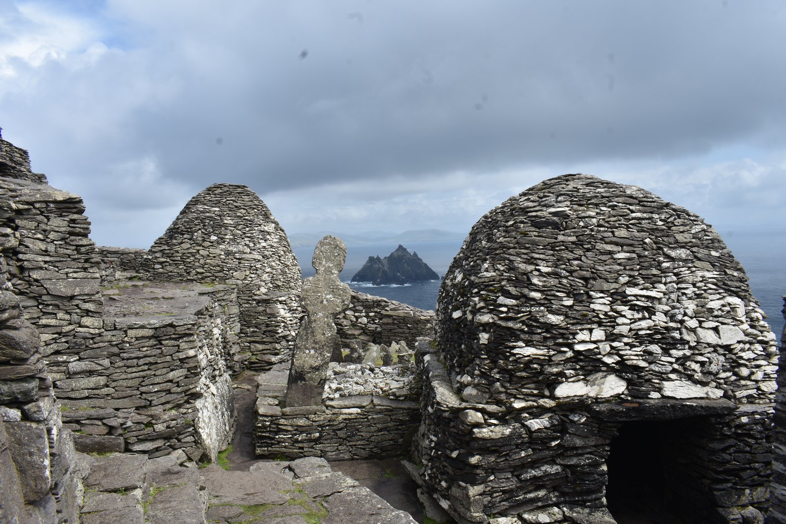 Beehive huts on Skellig Michael beneath a cloudy sky