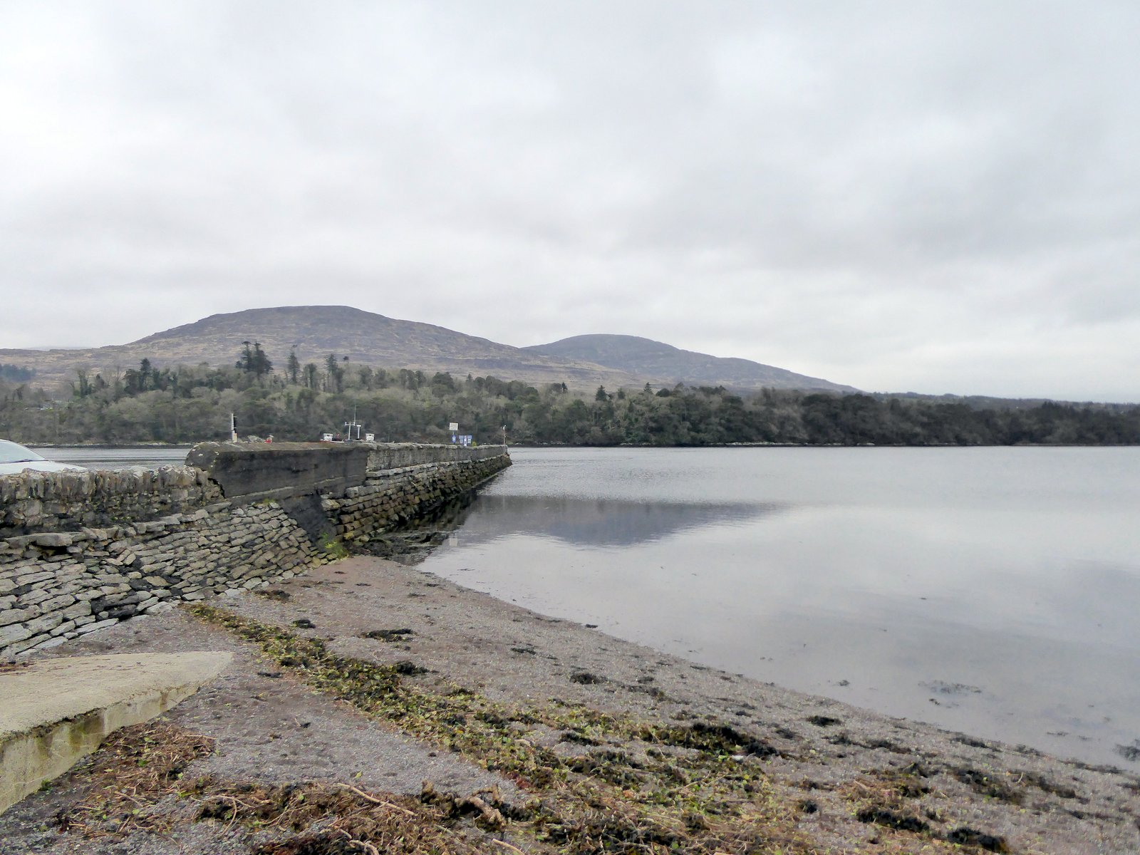 Stone pier beside still water in Kenmare Bay