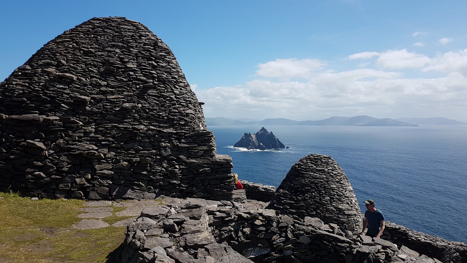 Stone beehive huts on Skellig Michael with Little Skellig visible across the water
