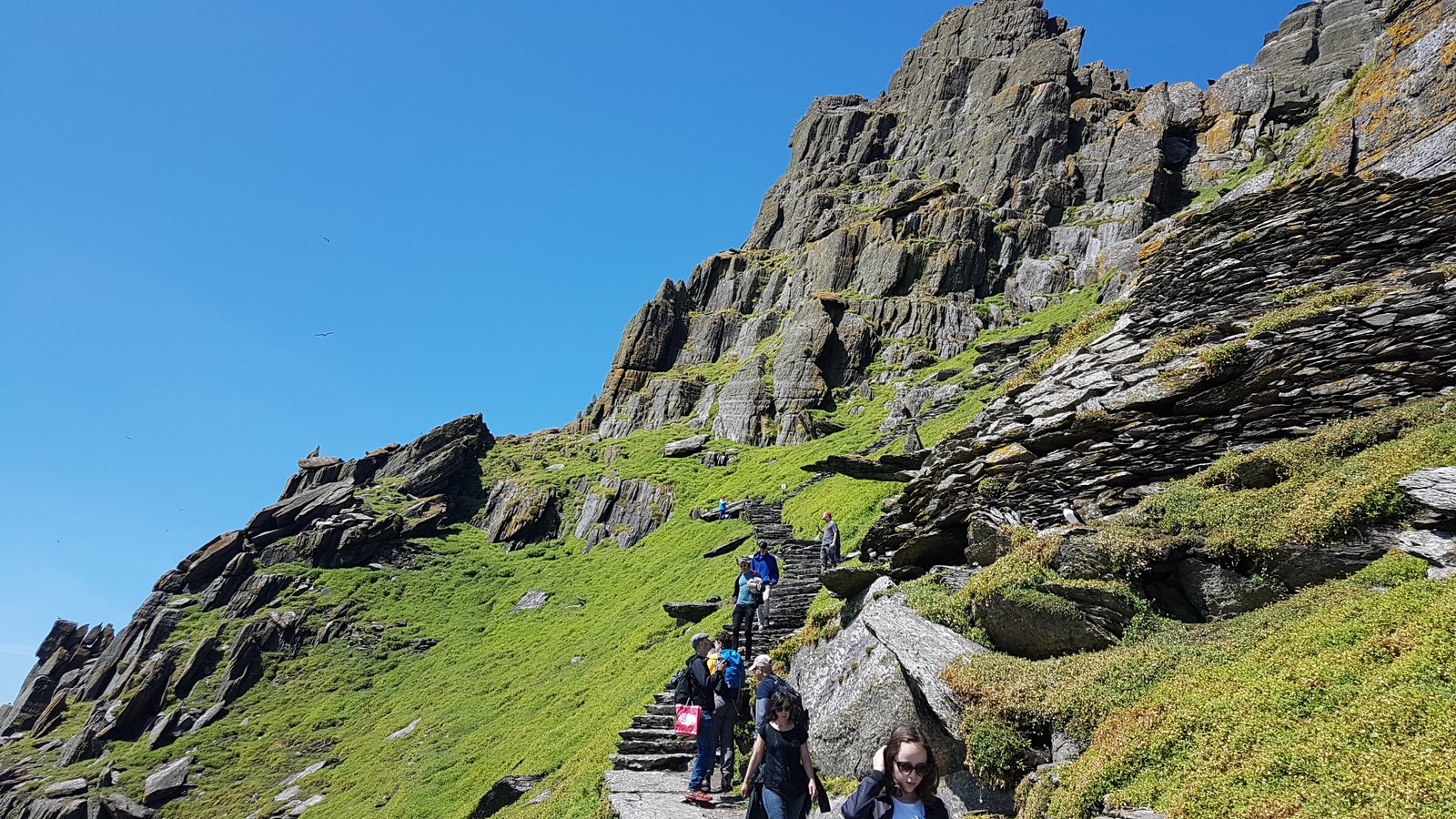 Tourists climbing the stone steps up Skellig Michael