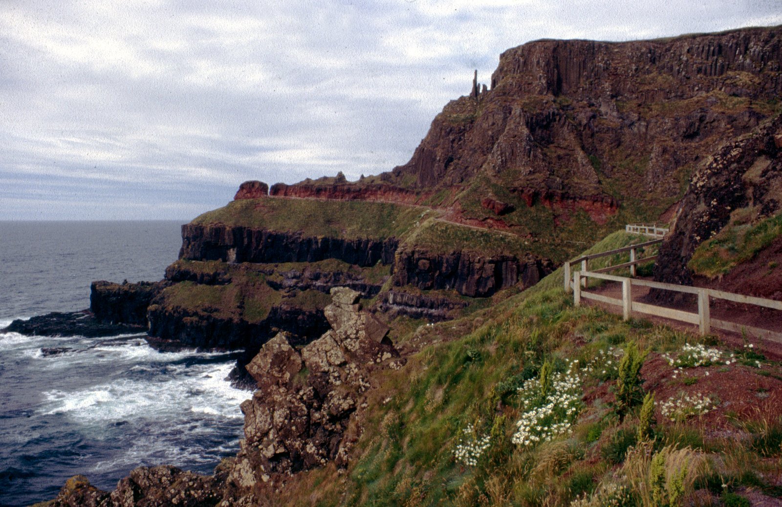 The exposed cliff-top path above the Giant's Causeway with a fence along the edge