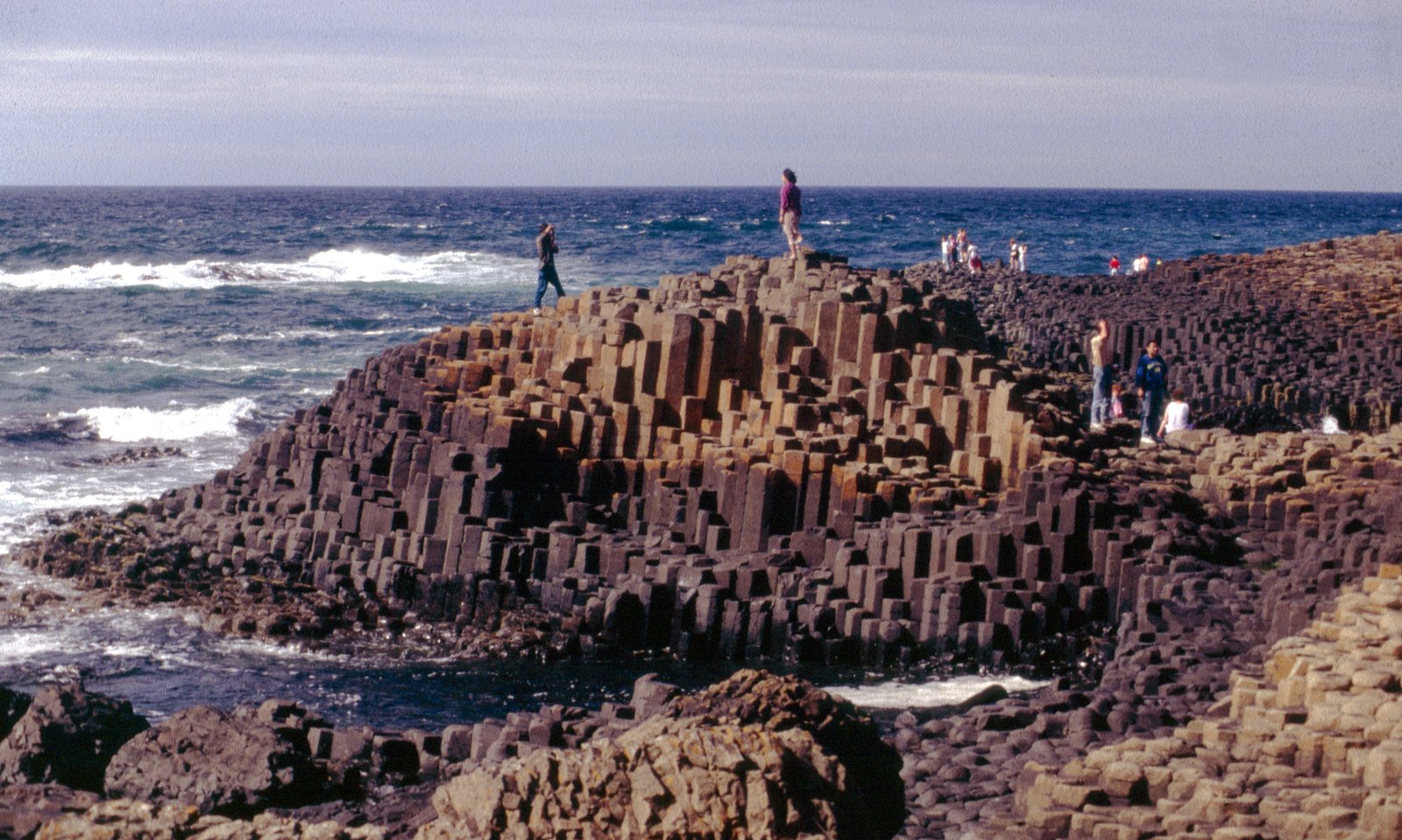 Tall stepped basalt columns at the Giant's Causeway with the sea beyond