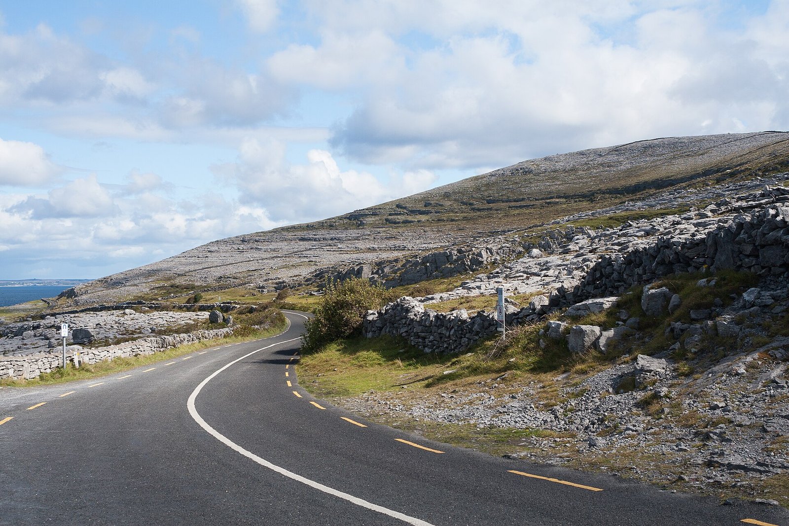 The R477 coast road beside limestone hills in the Burren, County Clare