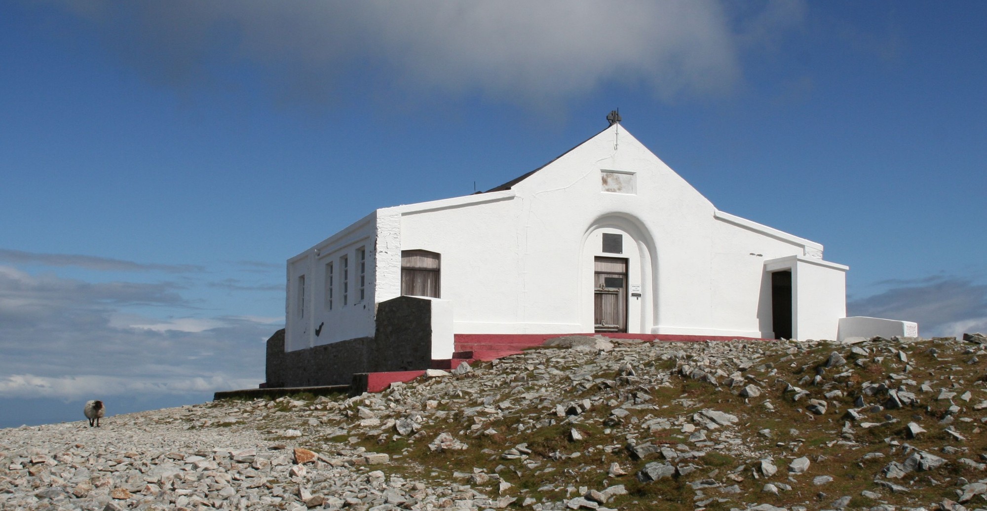 White chapel on Croagh Patrick summit under a blue sky