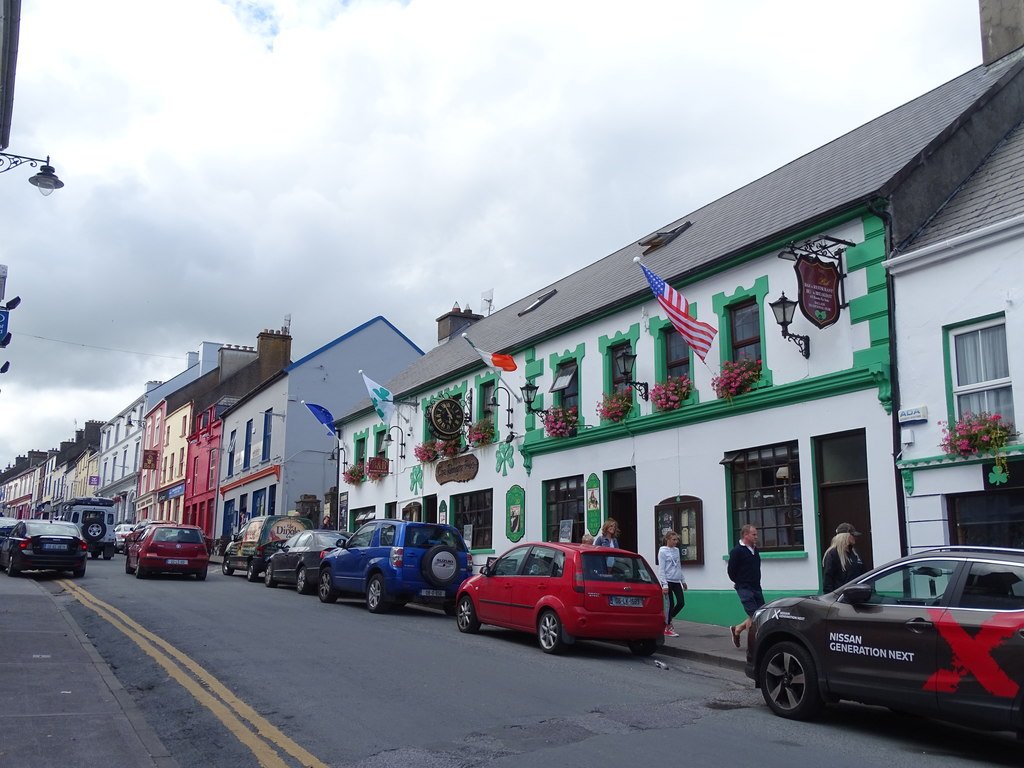 Main Street in Dingle with pubs and parked cars