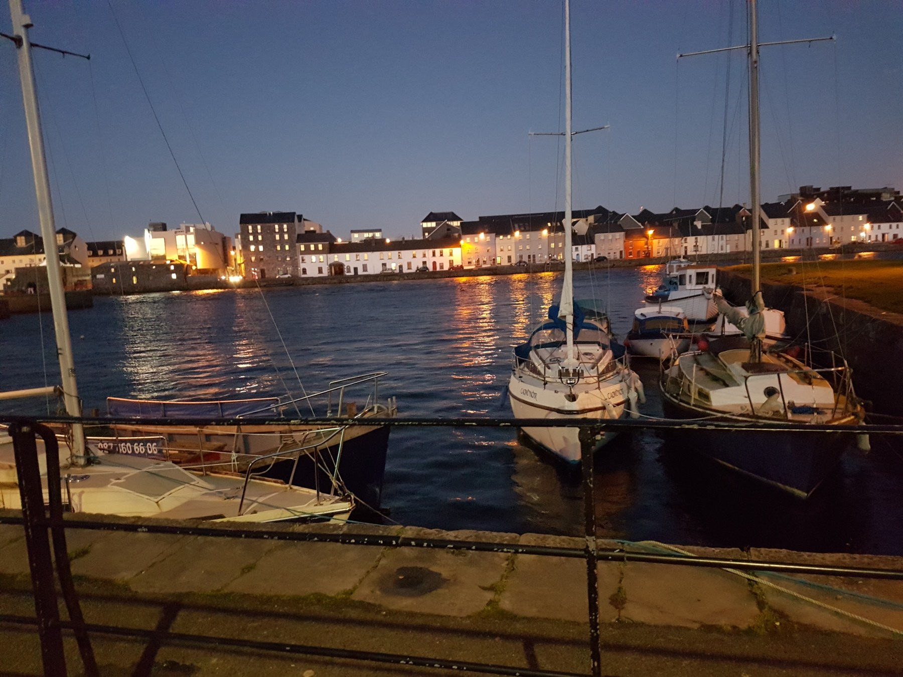 Boats beside Galway's riverside at dusk